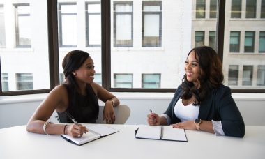 Two Woman in Black Sits on Chair Near Table